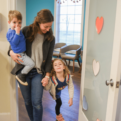 Oral health and school performance: is there a connection? 2 Parent and children entering a room at rva pediatric dentistry, representing oral health and school performance